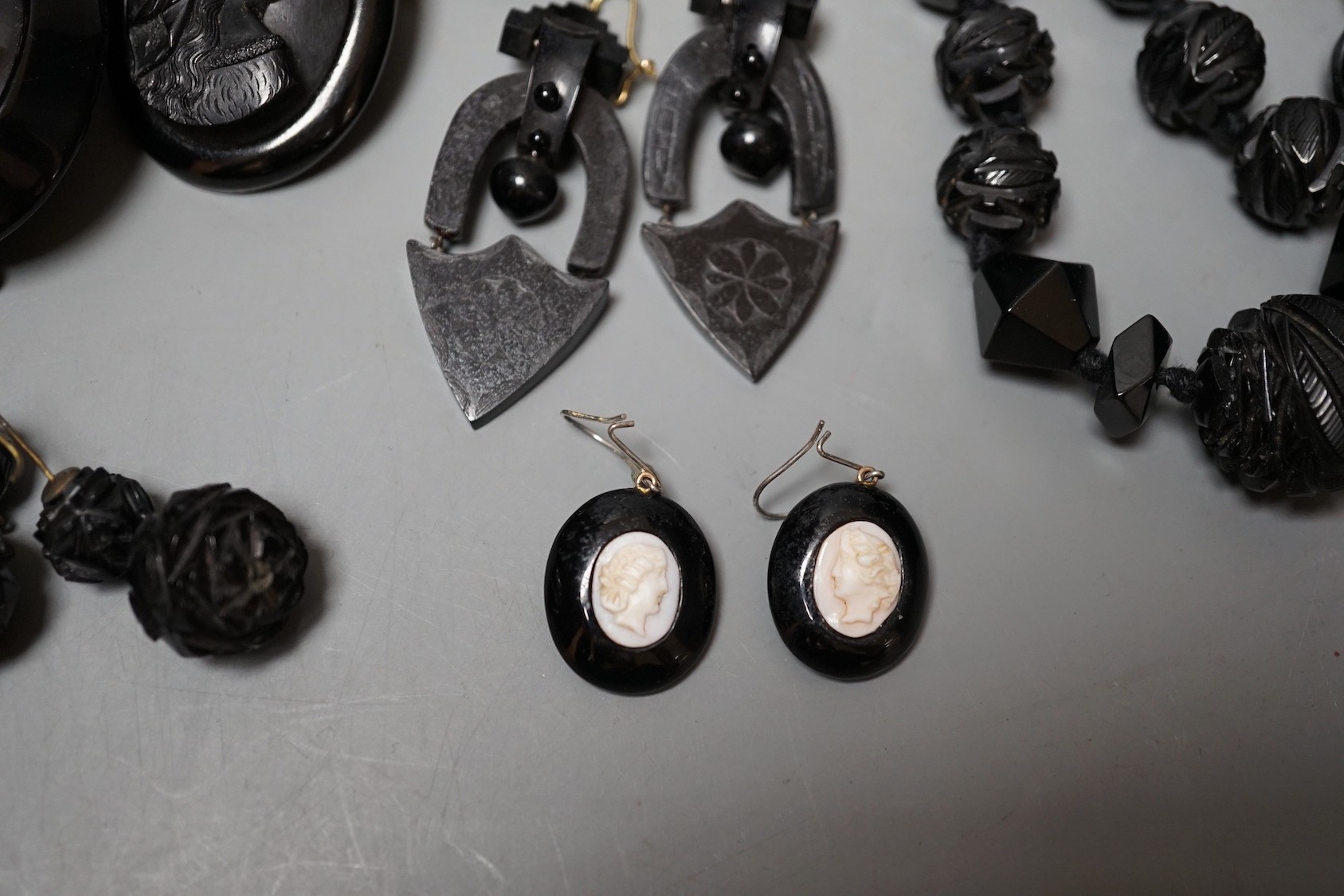 A collection of assorted jet jewellery, some with cameo, including two necklaces, five brooches, a bracelet and three pairs of earrings.